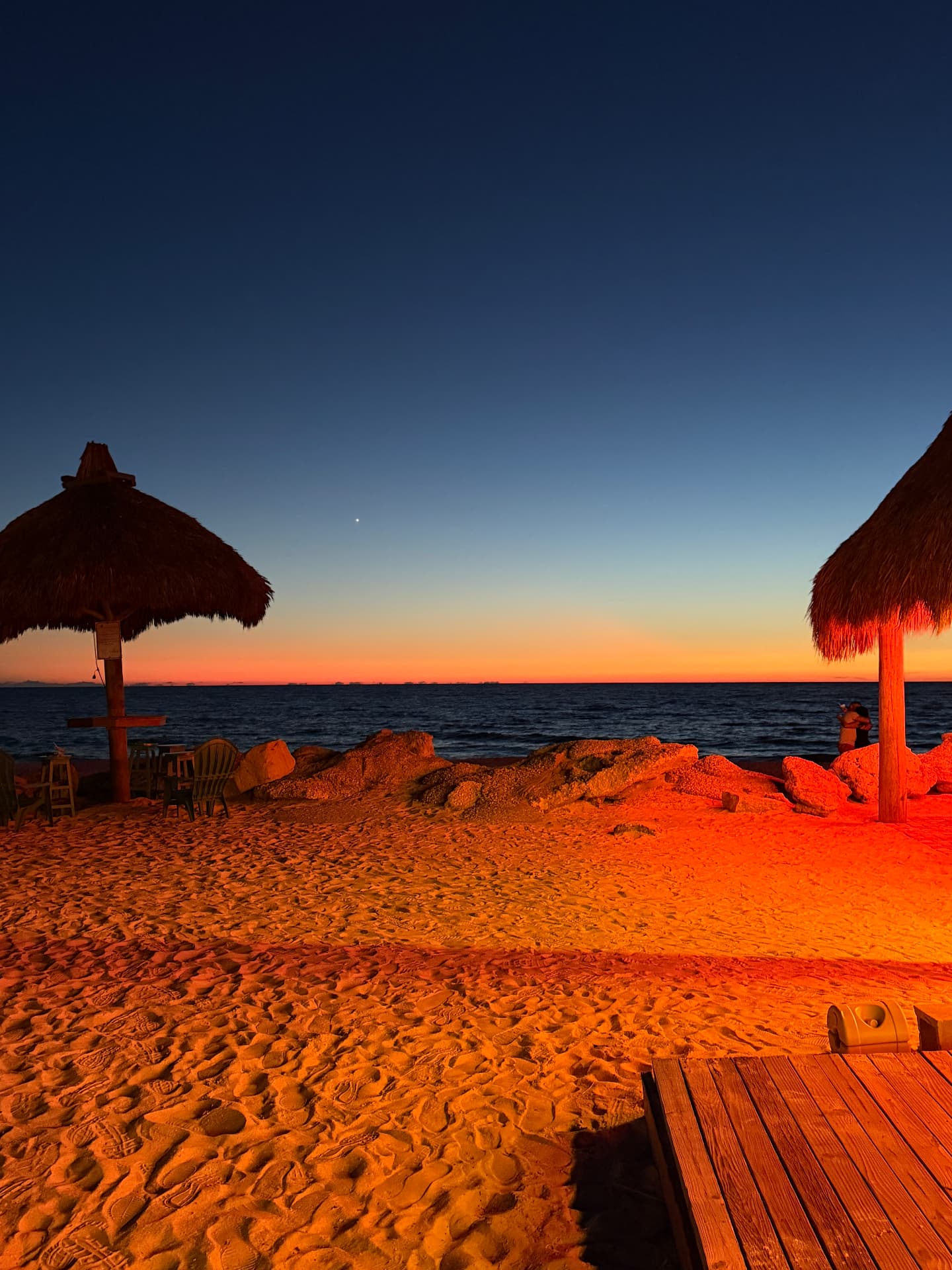 Tiki umbrellas and a vivid twilight sky along Anna Maria Island