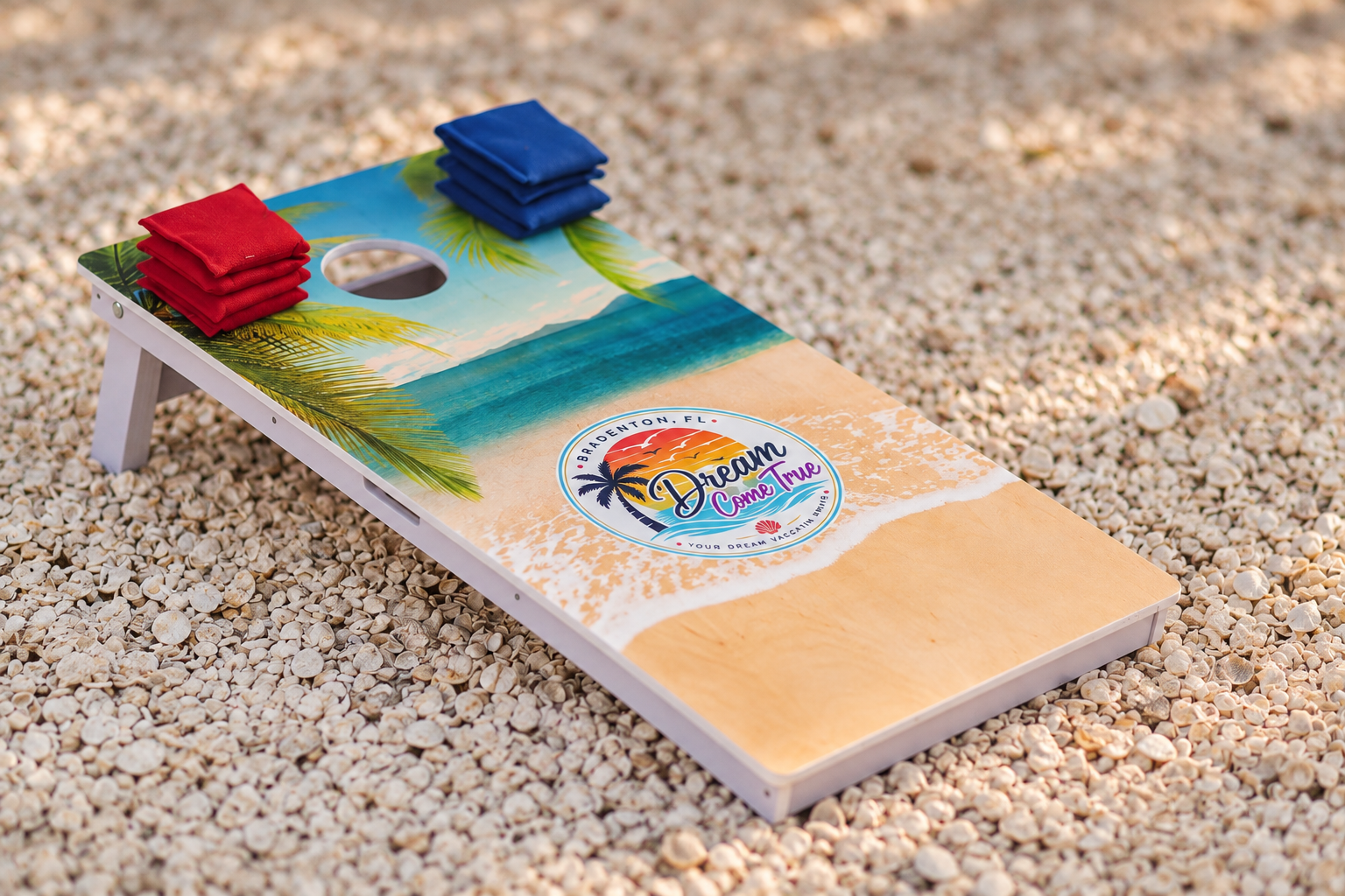 Dream Come True branded beach cornhole board set on a seashell path at Dream Come True in Bradenton, Florida