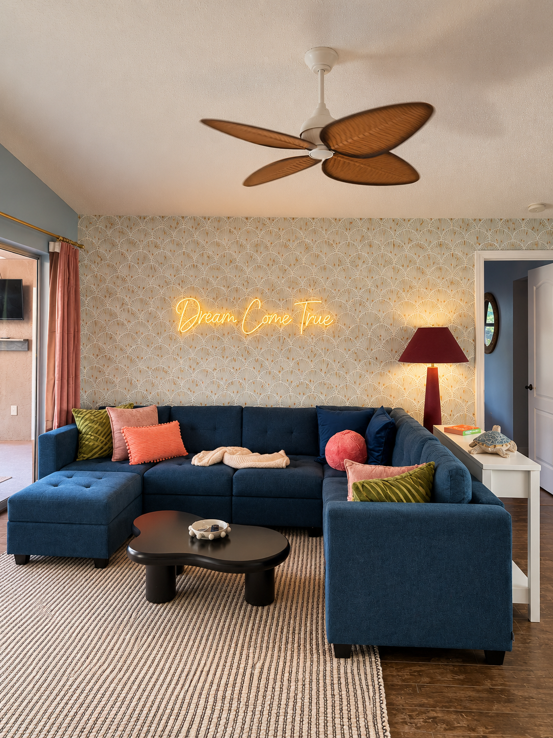Navy sectional sofa beneath a glowing Dream Come True neon sign on a scalloped wallpaper wall at Dream Come True in Bradenton, Florida