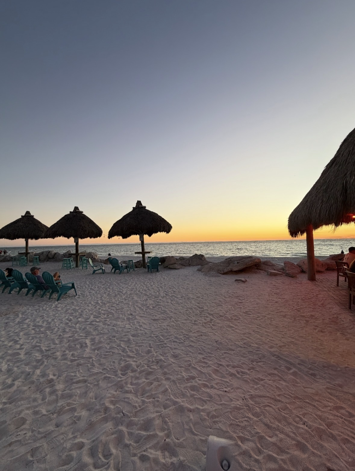 Beachside tiki umbrellas at sunset on Anna Maria Island